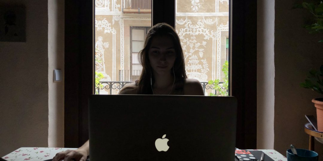 becaria chica estudiante a contraluz trabajando en un portatil